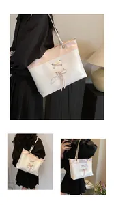 Detail of contrast color tote bag with ribbon bow and spacious interior design