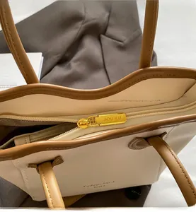 Close-up of smooth gold zipper and stitching detail on a contrast color tote bag