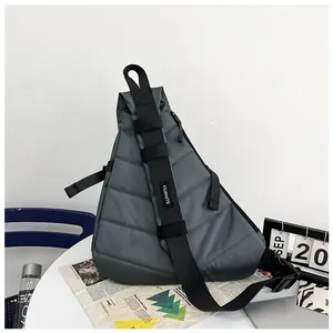 Detail showing the quilted grey crossbody bag with adjustable wide branded shoulder strap