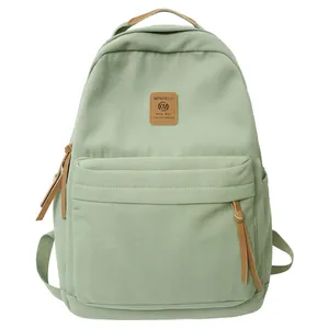 Minimalistischer hellgrüner Canvas-Rucksack mit braunem Lederlogo und Reißverschlüssen