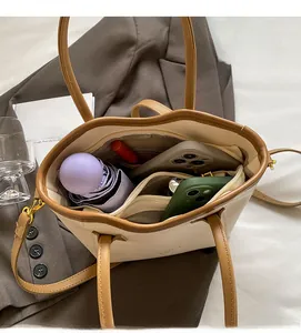 Interior view showing the large capacity and multi-pocket layout of the cream tote bag