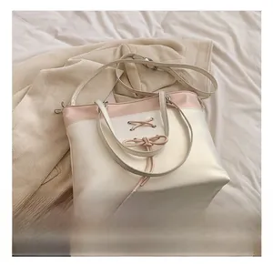 Detail of laser tote bag featuring ribbon bow design and dual-tone pink patchwork texture
