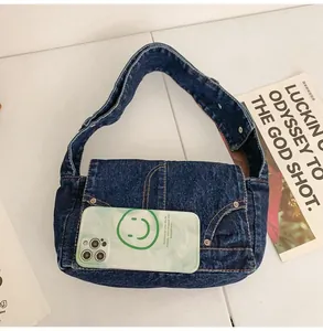 Détail d'un grand sac en jean avec poches vintage et smartphone pour l'échelle