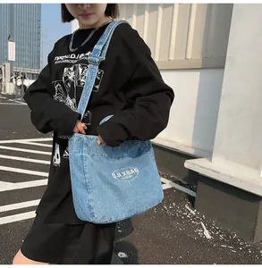 Detail of light blue denim crossbody bag with white JLXBAG 2008 embroidered logo