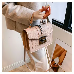 Detail der rosa Kunstledertasche mit Kroko-Struktur und Metallkette im natürlichen Licht