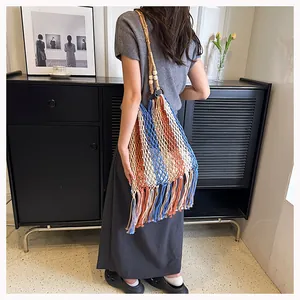 Detail of multi-color striped woven tote bag with fringe tassels and wooden bead accents
