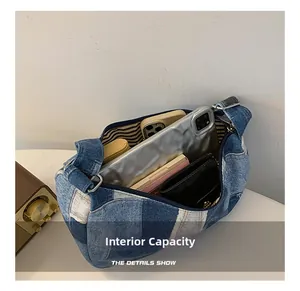 Detail view showing internal capacity of denim patchwork bag with striped lining