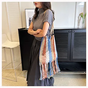 Detailed view of woven beach bag featuring colorful tassels and wood bead shoulder strap