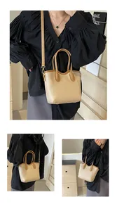 Detail view of contrast beige and brown PU leather bucket bag with gold hardware
