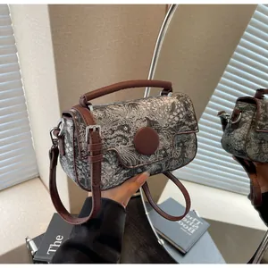 Detail of vintage floral jacquard handbag with brown leather strap and metal buckle closure