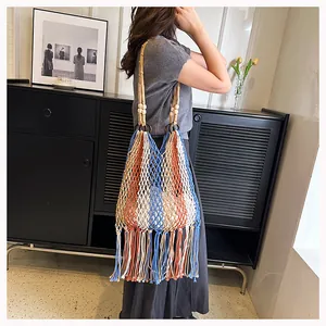 Detail of bohemian tricolor woven bag featuring soft tassels and wooden bead strap