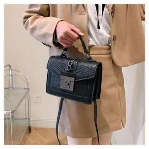Detailansicht der schwarzen Kroko-Handtasche mit Metallkette und quadratischem Verschluss