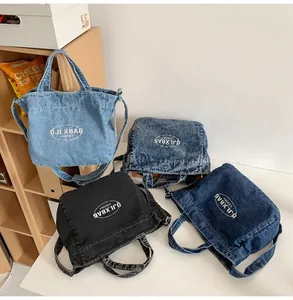 Detail view of four colors of denim tote bags with white letter prints and double straps