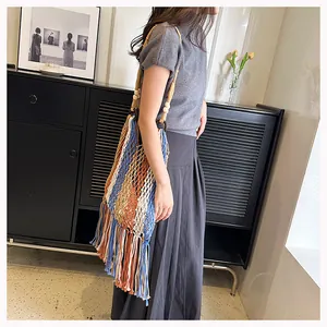 Detail of bohemian striped woven bag with long fringe and decorative wooden beads