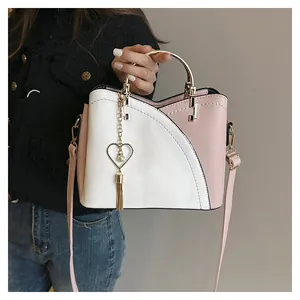 Dettaglio borsa patchwork in pelle rosa e bianca con manico oro e nappa