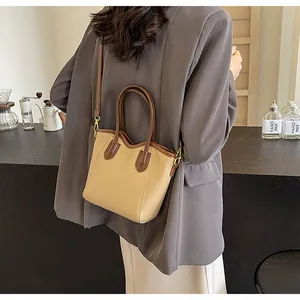 Detail view of a color-block bucket bag with PU leather texture and detachable strap
