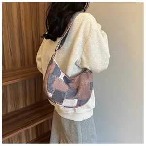 Detailed side view of a patchwork canvas hobo bag with a stylish adjustable shoulder strap