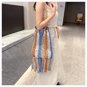Detail of hand-woven striped beach bag featuring long cotton tassels and boho style