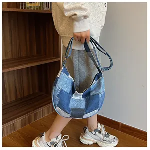 Detail of vintage denim patchwork hobo bag showing layered fabric and texture
