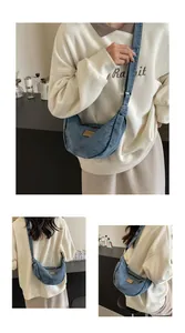 Vue détaillée du sac bandoulière en denim délavé en forme de croissant avec sangle réglable