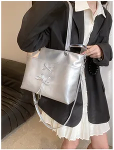 Detail of silver ballet-style tote bag with lace-up bow and adjustable shoulder strap