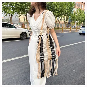 Detail view of woven beach bag featuring multi-color stripes, fringe, and wooden beads