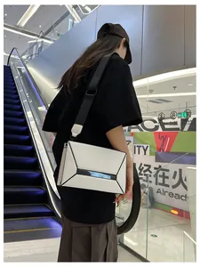 Detail of geometric puzzle crossbody bag with wide strap in black and white finish