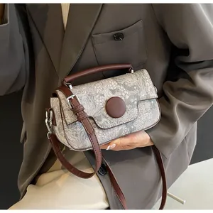 Close-up of vintage jacquard fabric handbag with brown leather trim and silver hardware