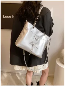 Detail of silver balletcore tote bag featuring ribbon bows and adjustable strap