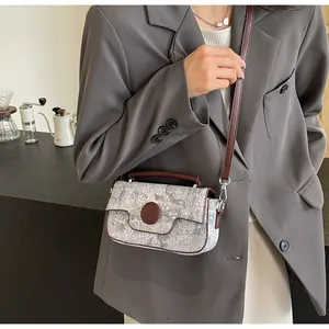 Detail of vintage floral crossbody bag with brown leather trim and adjustable shoulder strap