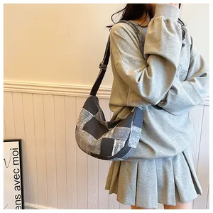 Detail of retro patchwork denim shoulder bag with adjustable strap on a female model