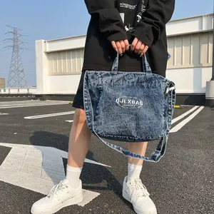Large dark blue washed denim tote bag with adjustable shoulder strap and logo print