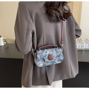Model wearing a retro floral crossbody bag with brown leather straps and metal buckle