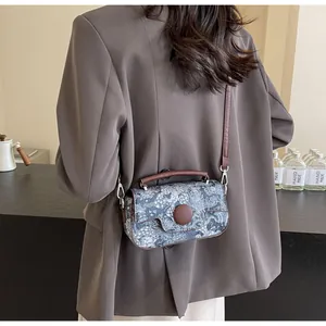 Detail view of vintage floral jacquard shoulder bag with circular snap closure and strap