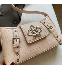 Detail of light pink crocodile pattern handbag with silver butterfly metal buckle