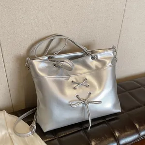 Silver metallic ballet-style tote bag with bow details and adjustable shoulder strap