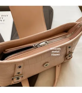 Detail of pink croc-effect bag showing silver metal zipper and smooth hardware closure