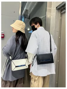 Close-up of geometric crossbody bags in black and beige shown by male and female models