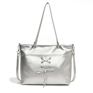 Large silver tote bag with metallic texture, ballet style ribbon detail, and top handles
