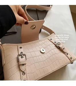 Detail view of the light pink crocodile pattern bag showing convenient magnetic closure