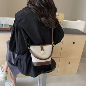 Canvas and brown leather patchwork bucket bag with golden buckle for casual commuting
