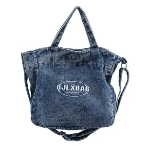 Vintage washed blue denim tote bag with adjustable strap and printed logo lettering