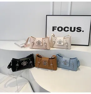 Multi-color stone pattern shoulder bags with fleur-de-lis buckles on a display stand