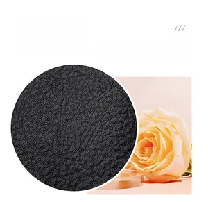 Detailed macro view showing premium black litchi grain leather texture on bag surface