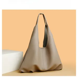 Close-up of soft lychee pattern leather and vertical stitching on taupe hobo bag