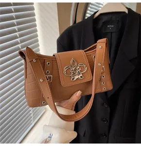 Close-up of brown crocodile embossed shoulder bag with unique silver butterfly metal buckle