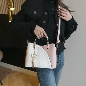 Borsa a secchiello color-block alla moda con manico in metallo e nappa a cuore