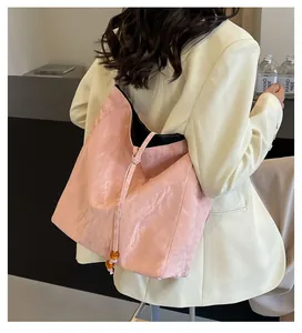 Bolso tote rosa texturizado con cierre de cordón y cuentas de ámbar decorativas
