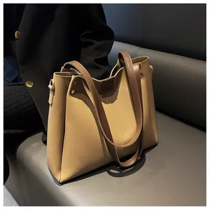Detail view of large bi-color leather tote bag showing stitching and wide shoulder strap
