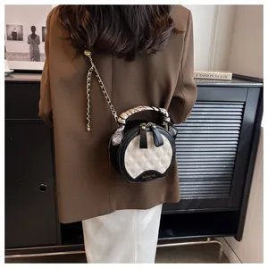 Détail du sac bandoulière rond matelassé avec poignée foulard et bandoulière chaîne